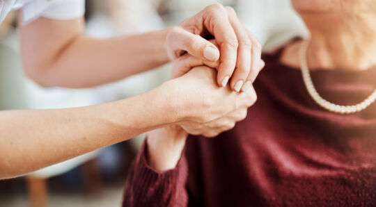 GettyImages-carer-and-older-patient-holding-hands-in-caring-way.jpg
